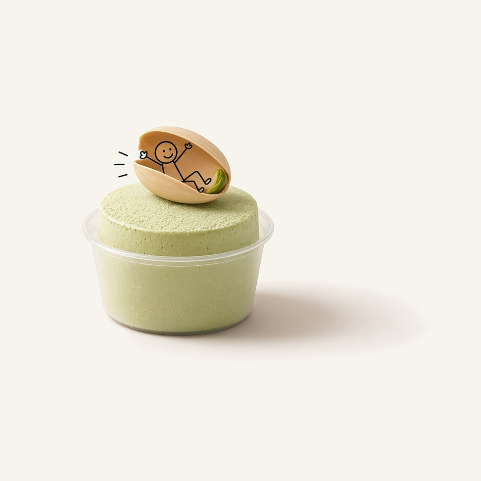 Pistachio snow ice block in a clear cup, with a line-drawn figure on top